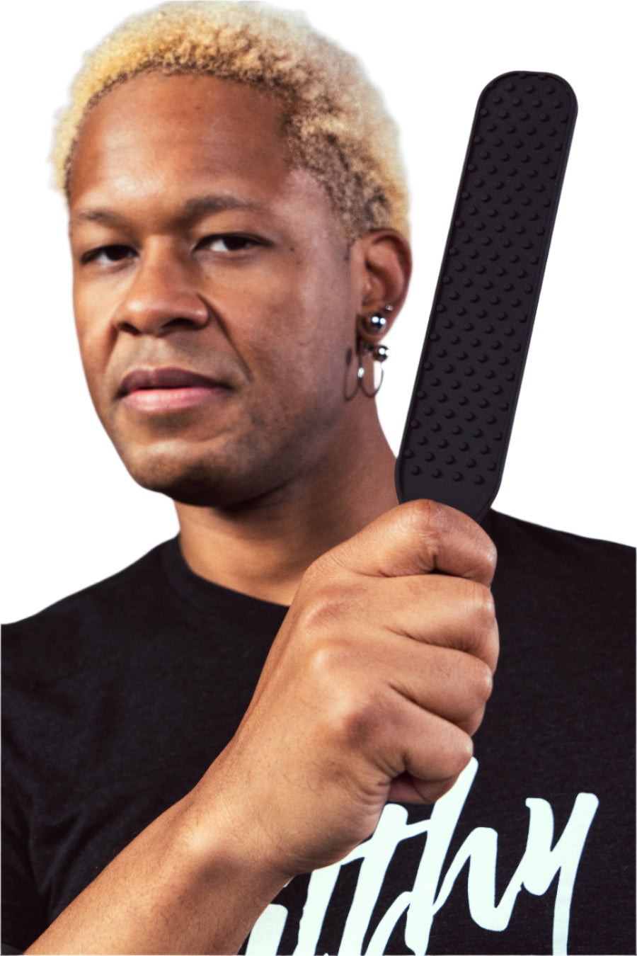 LT Holds a silicone paddle in front of their face. The paddle is slim and has raised dots for extra sensation.